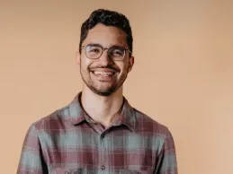 Team member posing in front of a neutral background